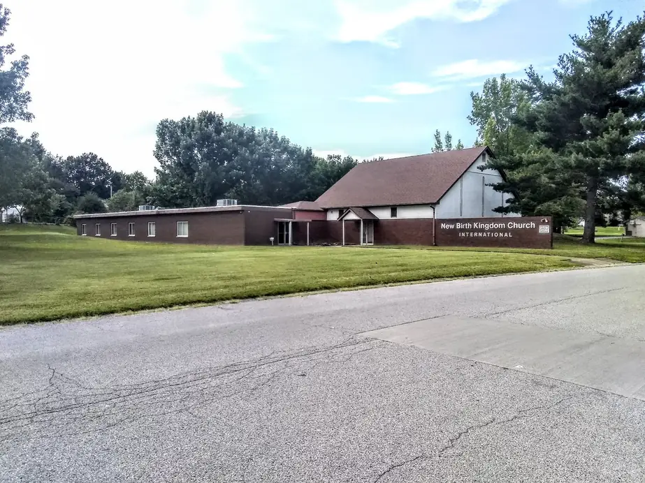 The long brick church building on N Robinson Circle seen from the street across the lawn