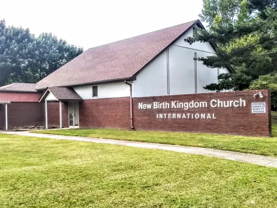 The entrance porch of New Birth Kingdom Church International beside its red brick sign wall